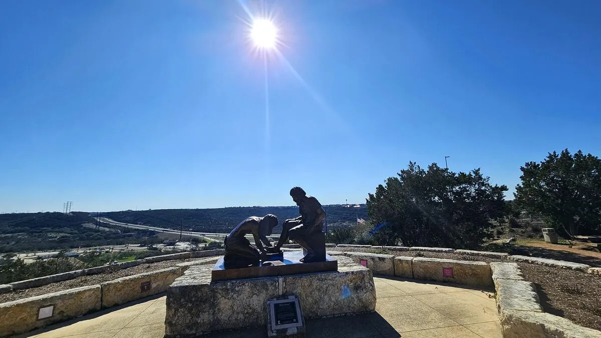 A statue of Jesus washing feet — divine humility and servanthood under the sunlight